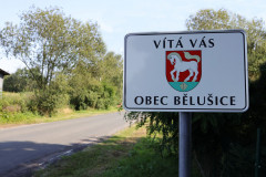 Cedule s nápisem vítá vás obec Bělušice na začátku obce
